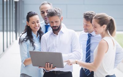 Group of diverse professionals collaborating around a laptop, discussing logistics solutions and business strategies.