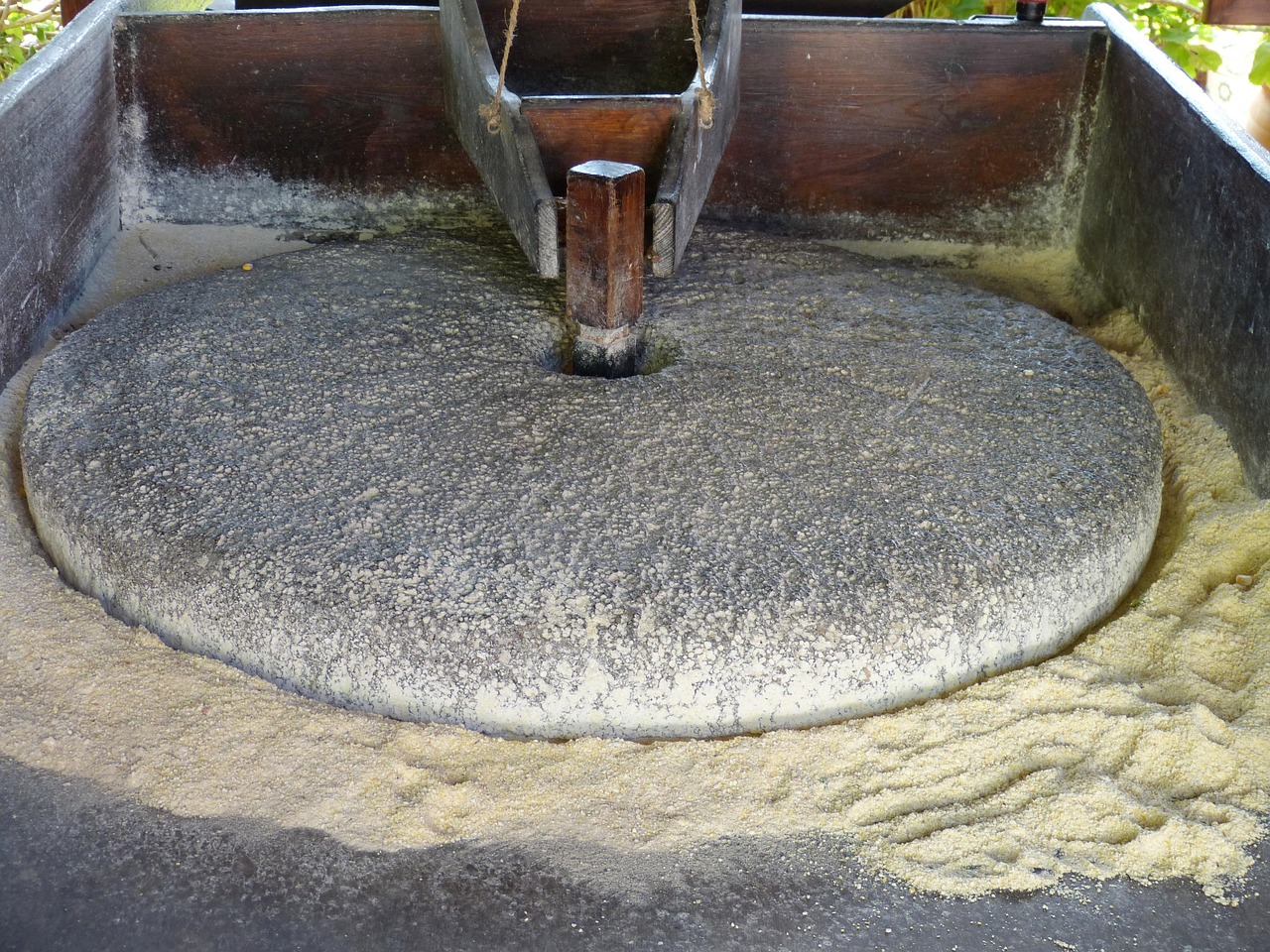 Stone grinding mill used for processing grains, emphasizing the theme of "Grind" in the context of business growth and leadership insights from Gracchus Partners.